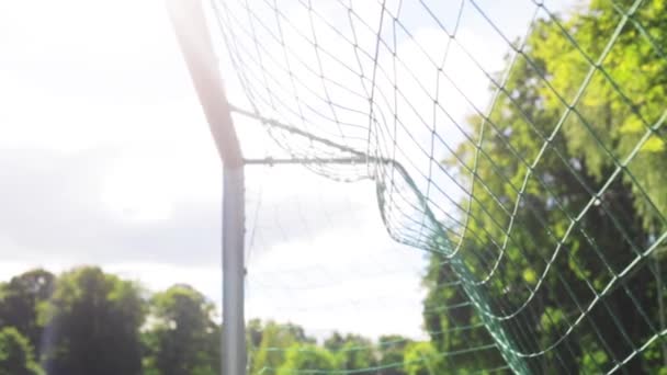 Ball flying into football goal net on field — Stock Video