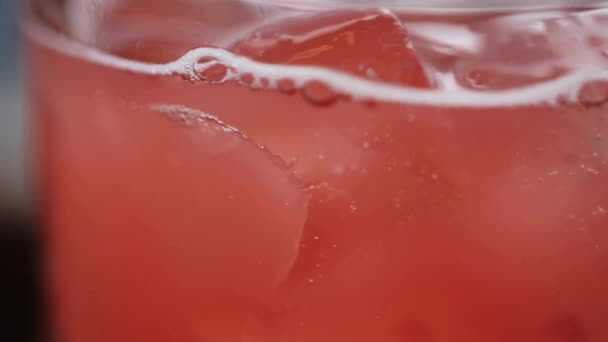 Rosa Limonade im Glas mit Eiswürfeln — Stockvideo