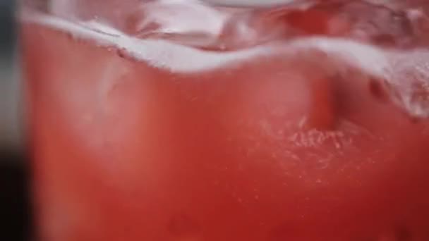 Ροζ λεμονάδα ποτά σε ποτήρι με παγάκια — Αρχείο Βίντεο