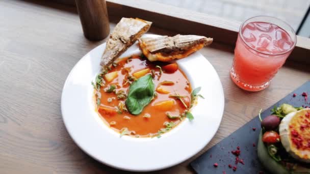 Sopa de gazpacho, ensalada y bebida en el restaurante — Vídeos de Stock