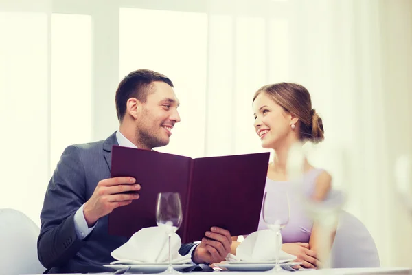 Coppia sorridente con menù al ristorante — Foto Stock