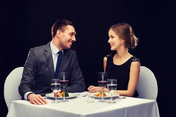 Casal sorrindo comer prato principal no restaurante — Fotografia de Stock