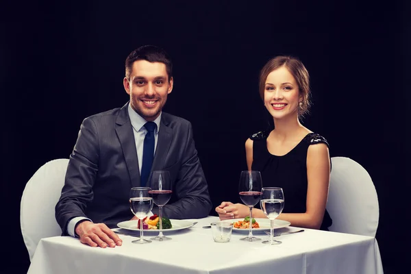 Pasangan tersenyum makan hidangan utama di restoran — Stok Foto