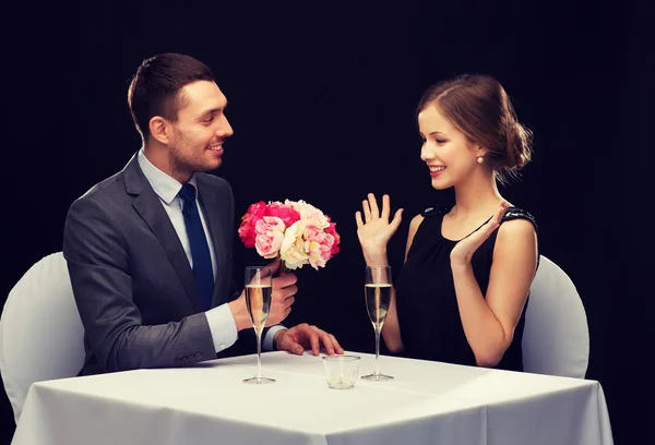 Homme souriant donnant bouquet de fleurs à la femme — Photo