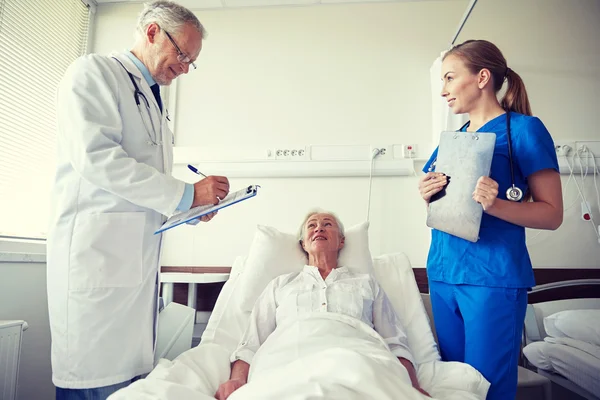 Arzt und Krankenschwester besuchen Seniorin im Krankenhaus — Stockfoto