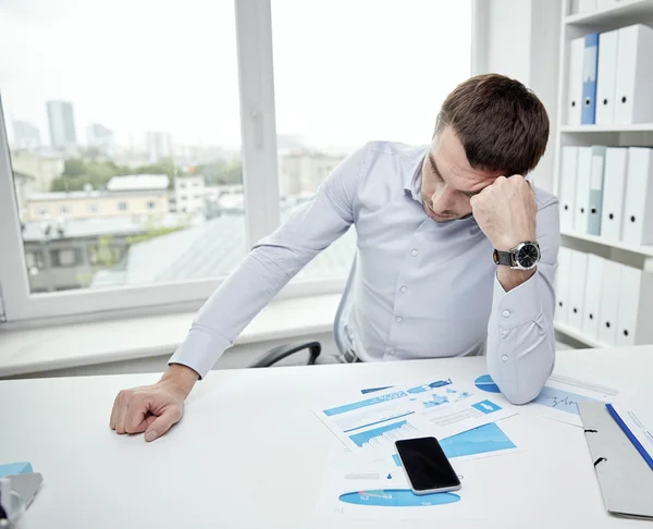 Benadrukt zakenman met documenten in office — Stockfoto