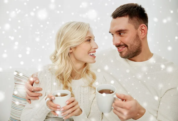 Casal feliz com copos bebendo chá em casa — Fotografia de Stock