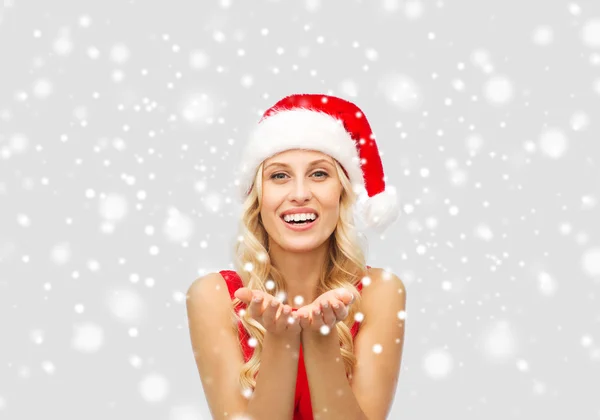 Happy woman in santa hat holding something on palm — Stock Photo, Image