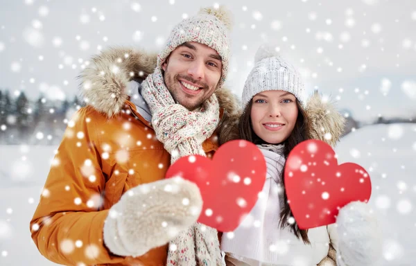 Kış manzara üzerinde kırmızı kalpler ile mutlu çift — Stok fotoğraf