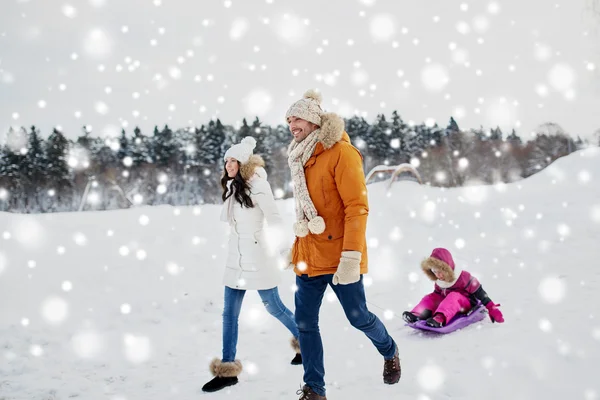 幸福的家庭，与雪橇行走在冬天的户外 — 图库照片