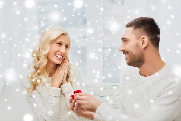 Szczęśliwy człowiek daje pierścionek zaręczynowy na kobiety w domu — Zdjęcie stockowe