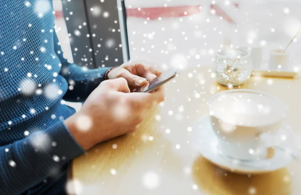 Close up of man with smartphones at cafe — Stock Photo, Image