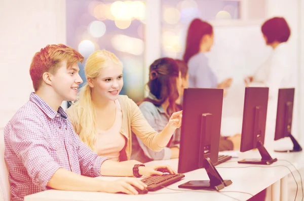 Estudiantes con monitor de computadora en la escuela —  Fotos de Stock