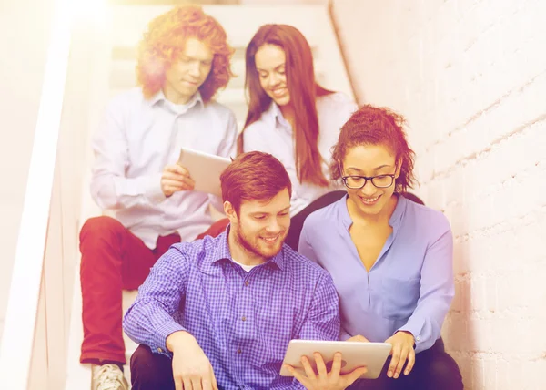 Team mit Tablet-PC sitzt im Treppenhaus — Stockfoto