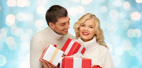Ευτυχισμένο ζευγάρι στο πουλόβερ κρατώντας τα δώρα Χριστουγέννων — Φωτογραφία Αρχείου