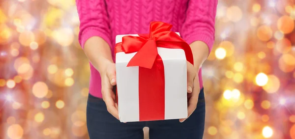 Close up of woman in pink sweater holding gift box Royalty Free Stock Images