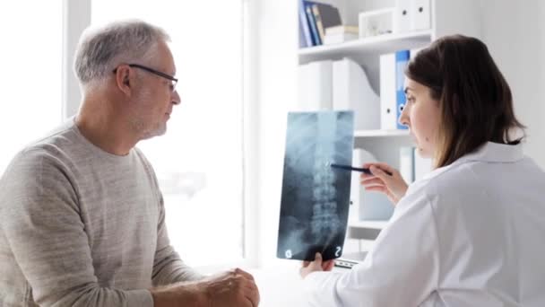 Врач с рентгеном позвоночника и пожилой человек в больнице 74 — стоковое видео
