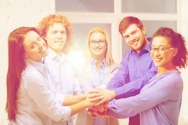 Team med händerna på varandra i office — Stockfoto