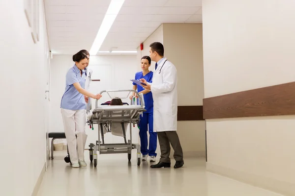 Medics with woman on hospital gurney at emergency — Stock Photo, Image