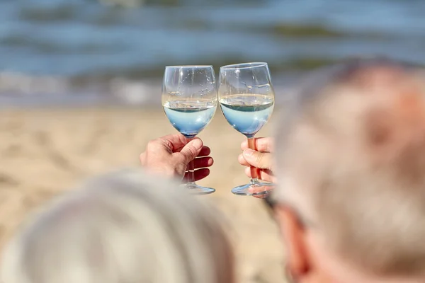 Feliz casal sênior beber vinho na praia de verão — Fotografia de Stock