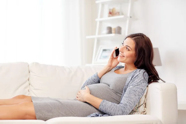 Mujer embarazada feliz llamando en el teléfono inteligente en casa — Foto de Stock