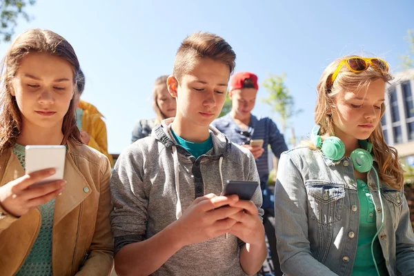 Grupo de amigos adolescentes com smartphones ao ar livre — Fotografia de Stock
