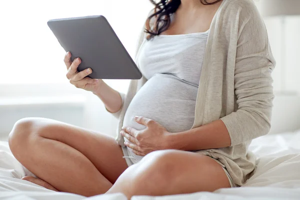 Zamknij się kobieta w ciąży z komputera typu tablet w domu — Zdjęcie stockowe