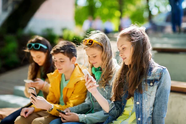 Щасливі друзі-підлітки зі смартфонами на відкритому повітрі — стокове фото