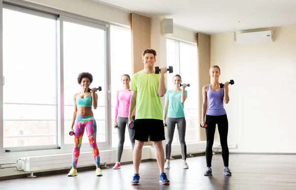 Groep lachende mensen trainen met halters — Stockfoto