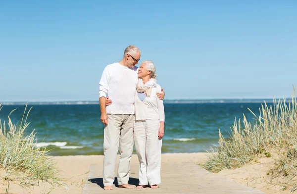 Happy senior couple hugging on summer beach — Stock Photo, Image