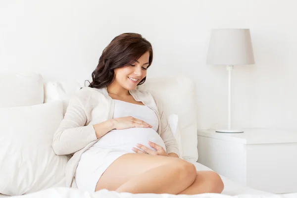 Mulher grávida feliz deitada na cama em casa — Fotografia de Stock