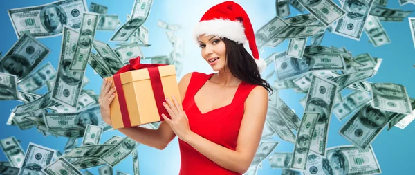 Bella donna in cappello di Babbo Natale con regalo sopra i soldi — Foto Stock