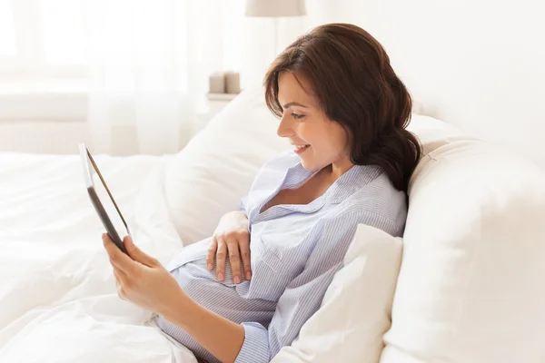 Mujer embarazada feliz con la tableta PC en casa — Foto de Stock