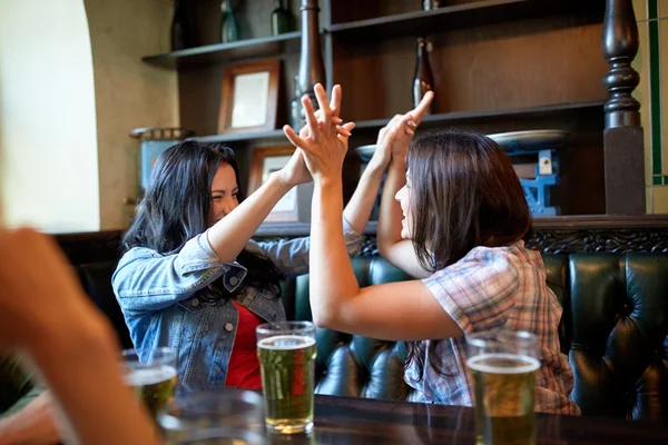 Счастливые друзья с пивом празднуют в баре или пабе — стоковое фото