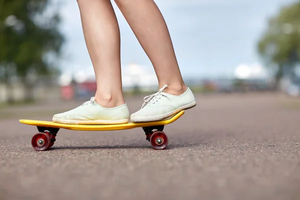 Gros plan de pieds féminins chevauchant skateboard court — Photo