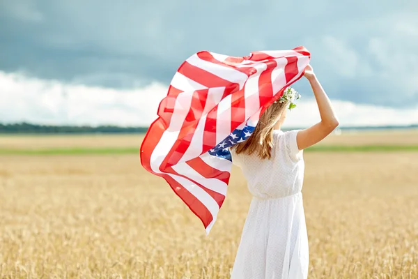 Mulher feliz com bandeira americana no campo de cereais — Fotografia de Stock