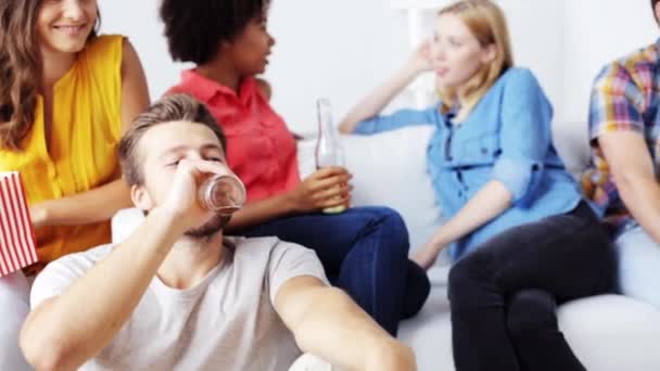 Amigos con palomitas de maíz y cerveza viendo la televisión en casa — Vídeos de Stock