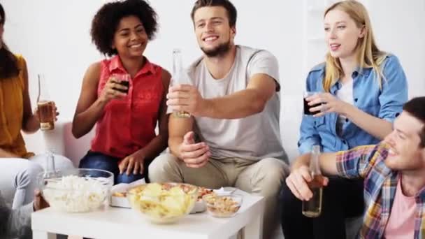 Друзья с напитками и закусками разговаривают дома — стоковое видео