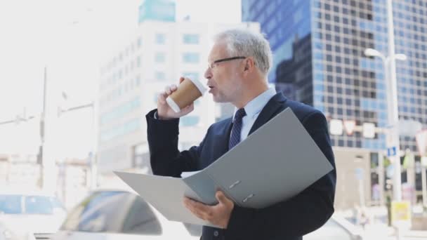 Старший бизнесмен с кофе и папкой в городе — стоковое видео