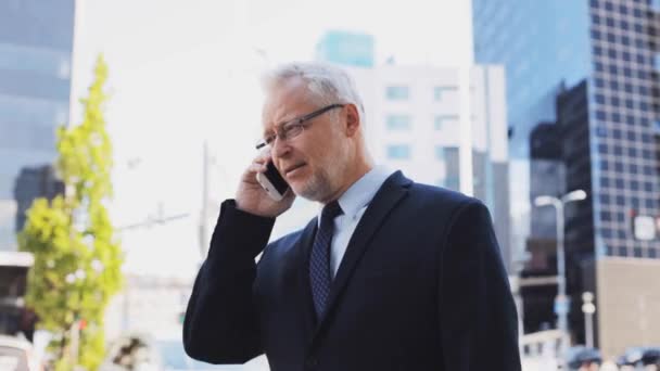 Hombre de negocios senior que llama en el teléfono inteligente en la ciudad — Vídeos de Stock