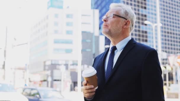 Senior businessman drinking coffee on city street — Stock Video