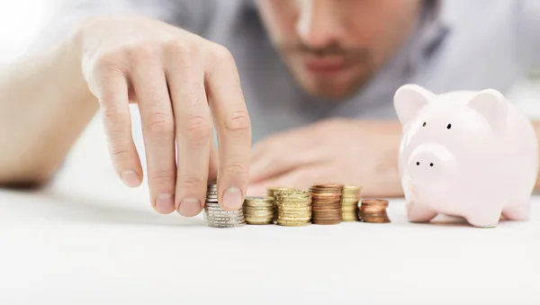 Close up van zakenman met piggy bank en munten — Stockfoto