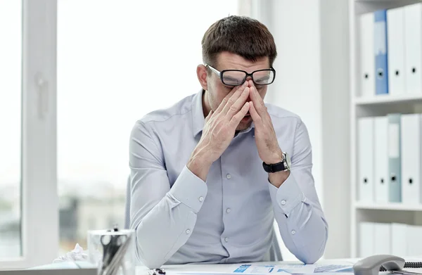 Empresário cansado com óculos no escritório — Fotografia de Stock