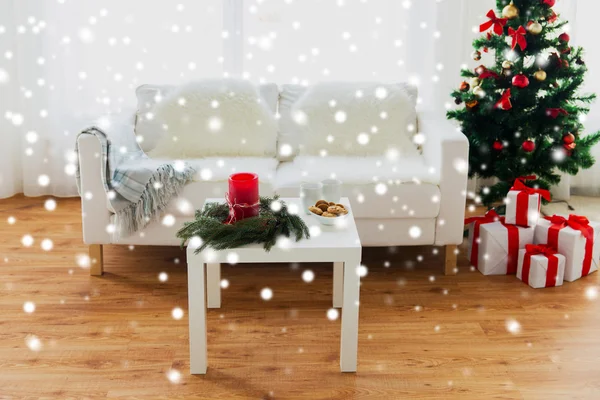 Sofá, mesa e árvore de Natal com presentes em casa — Fotografia de Stock