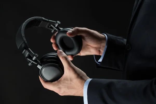 Close up of businessman hands holding headphones — Stock Photo, Image