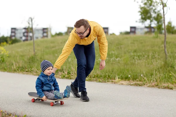 Gelukkig vader en zoontje rijden op skateboard — Stockfoto