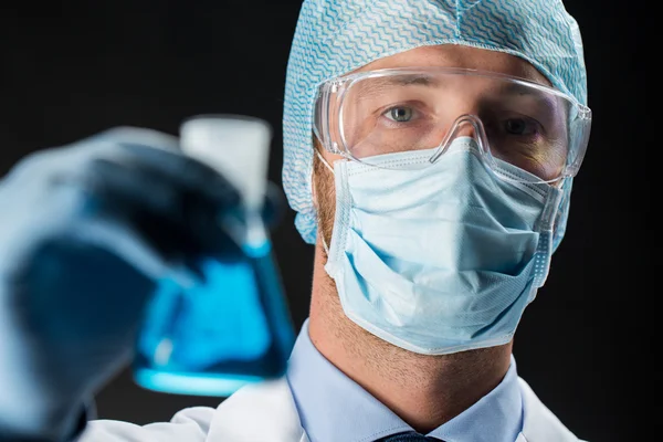 Nahaufnahme eines Wissenschaftlers, der eine Flasche mit Chemikalien in der Hand hält — Stockfoto