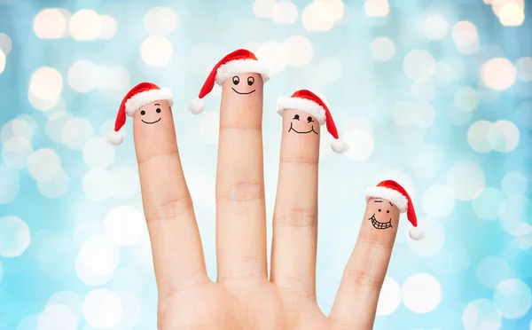 Gros plan de la main avec quatre doigts dans les chapeaux de Père Noël — Photo
