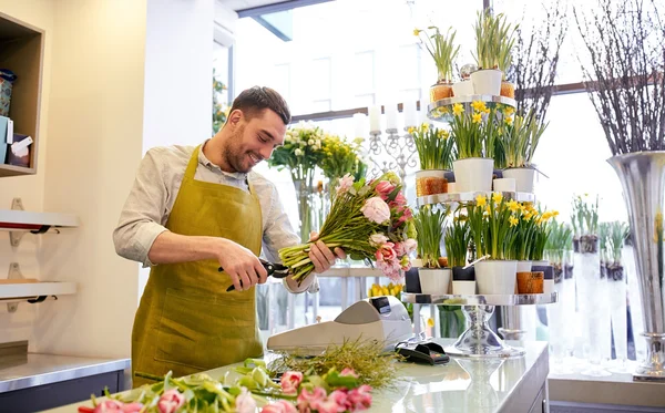 Sonriente florista hombre haciendo ramo en floristería — Foto de Stock