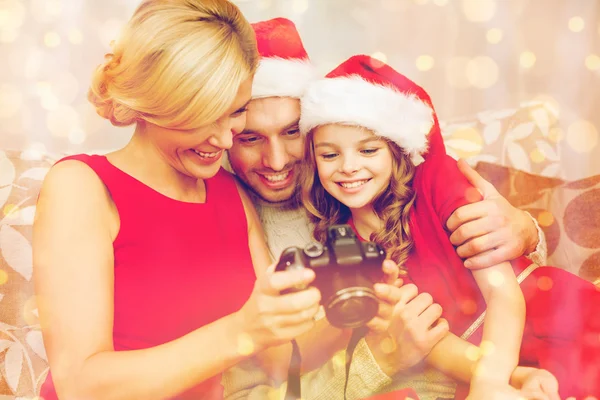 Семья в шляпах-помощниках Санта-Клауса смотрит на картины — стоковое фото